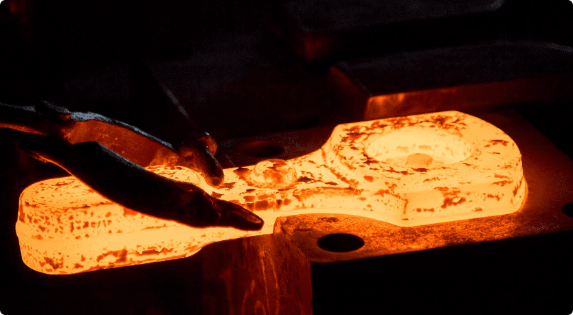Forging tongs hold a recently forged metal piece