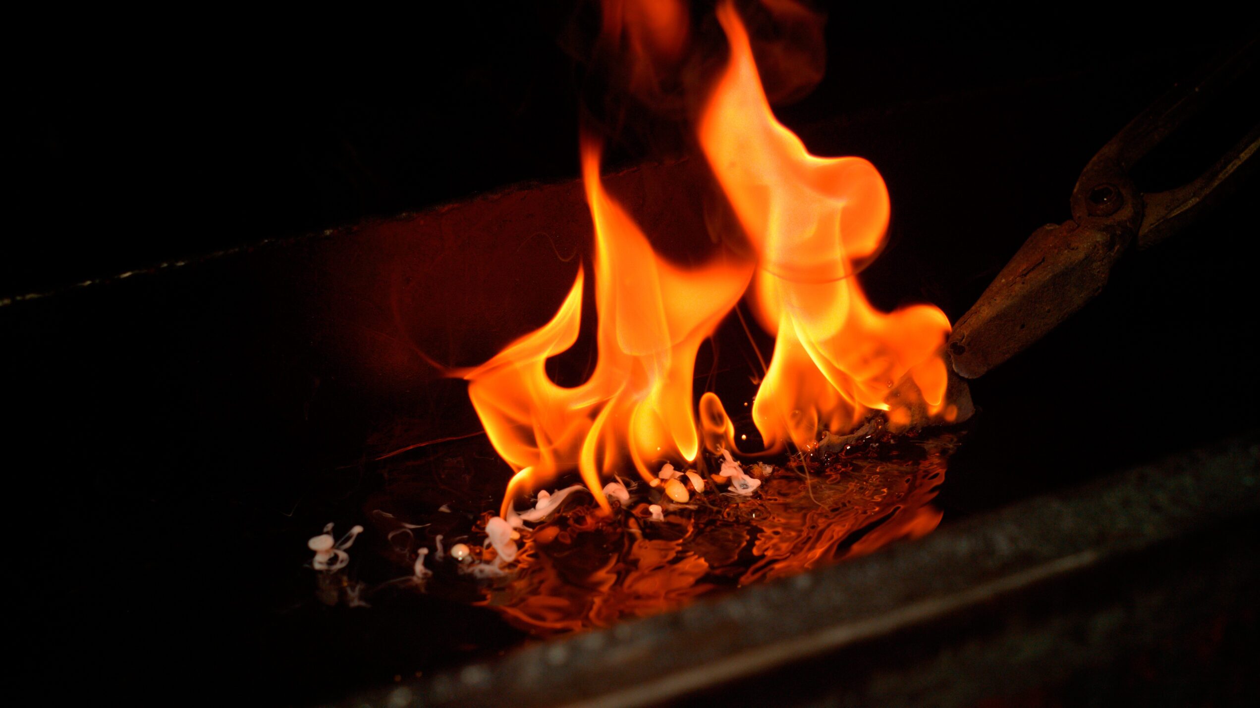 A knife being quenched in oil