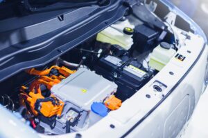 An electric vehicle with the hood opened, exposing under-the-hood components